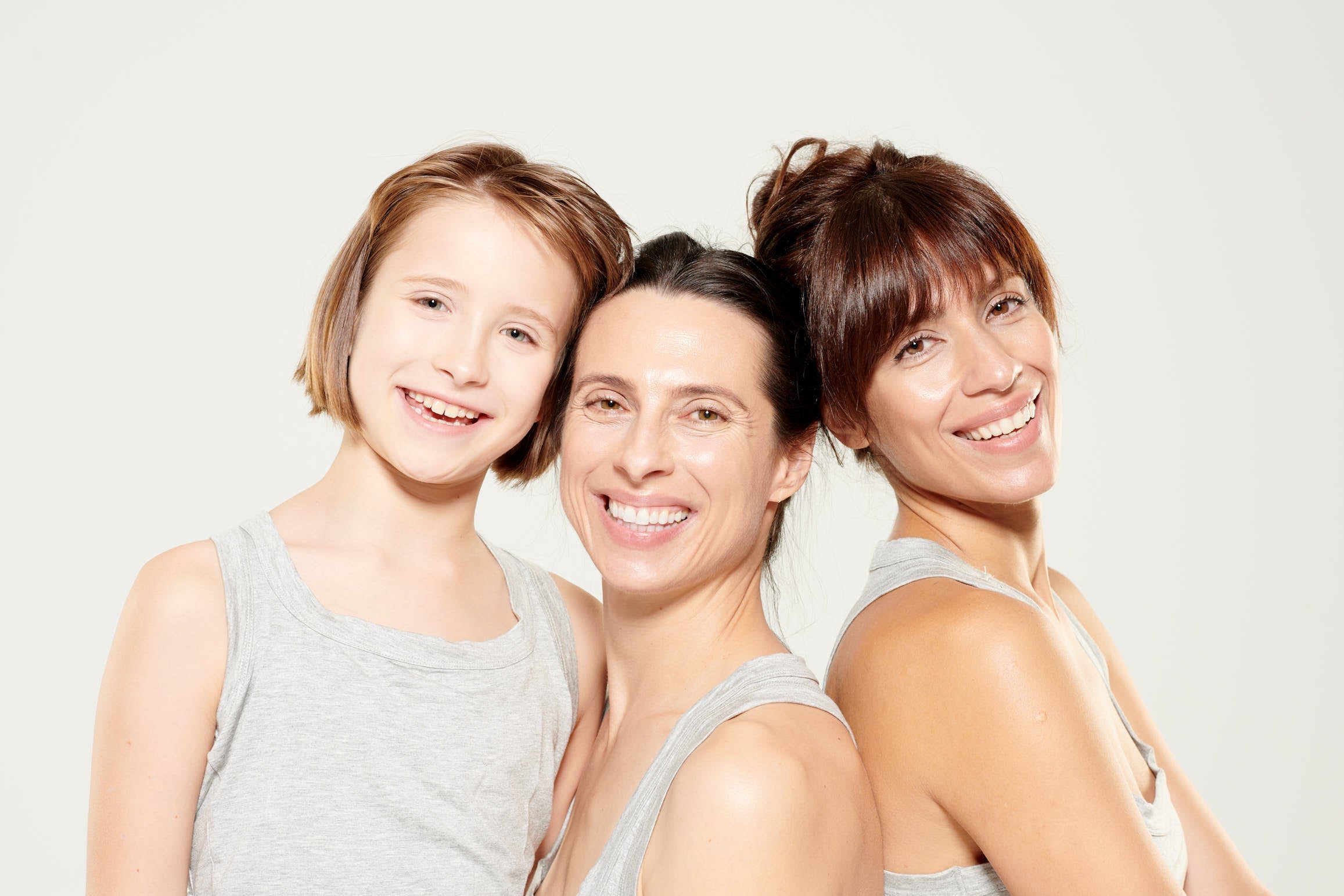 Three women standing close together against a white background